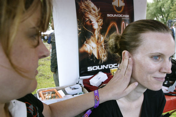 A woman gets fitted for Soundcage earplugs by Sonomax during the Virgin Music Festival in Toronto