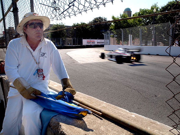 A flagman waits at a corner during Indy practices